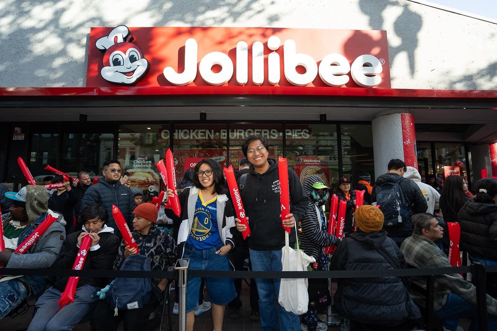 Opening-day crowd with Jollibee thundersticks under the red Market Street sign