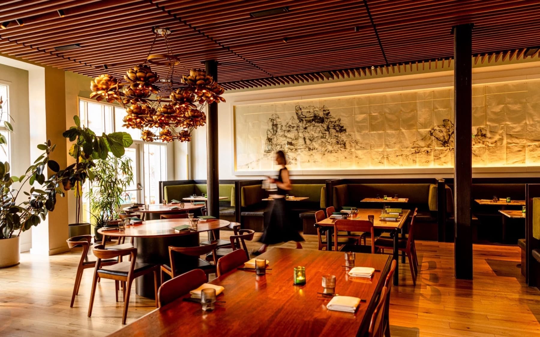 Mister Jiu’s San Francisco dining room with lotus chandelier, wood tables, and ink mural