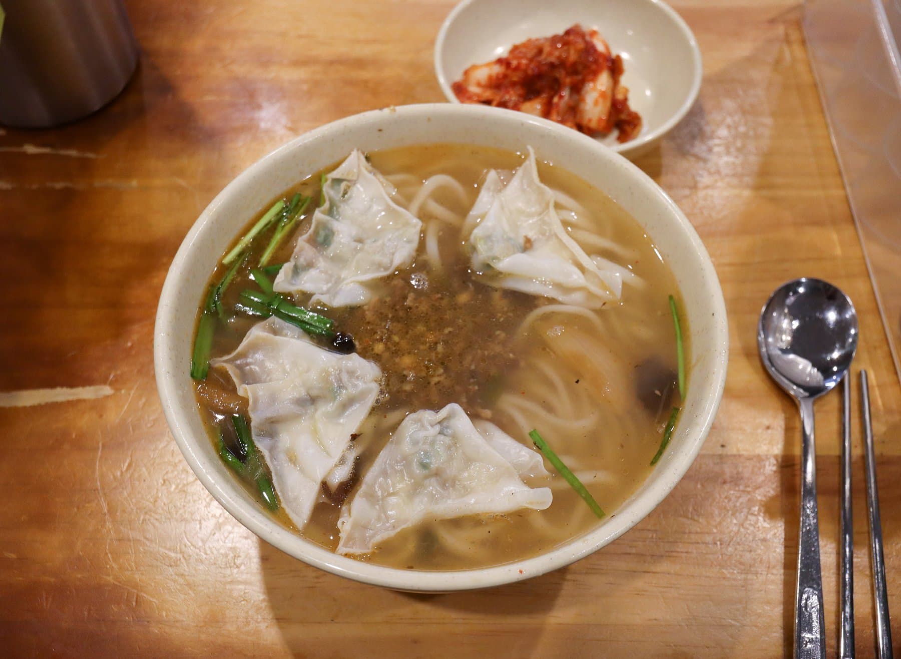 Bowl of kalguksu with dumplings and kimchi at Myeongdong Kyoja