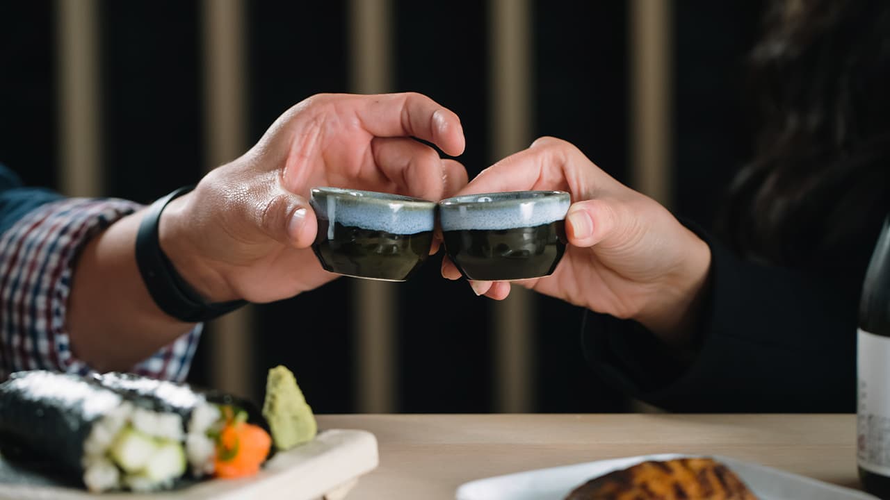 Sake toast over temaki and a wooden sushi board at Nori Handroll Bar