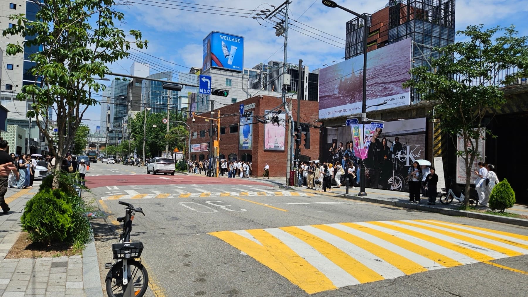 Busy Seongsu street with brick warehouses, brand billboards, and a pop-up queue