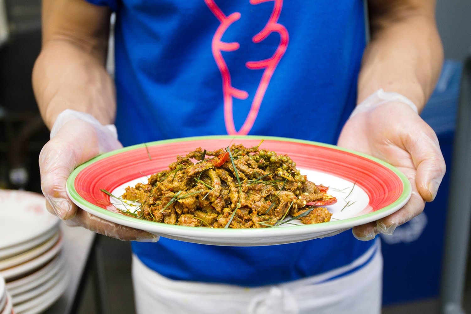 Chef Sirichai Sreparplarn holding a plate of kua kling at the original Ugly Baby