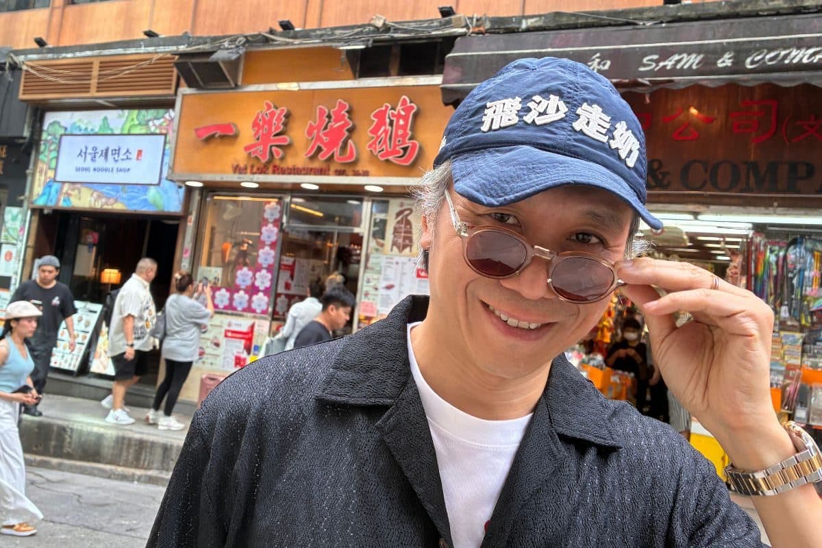 Portrait of Kent Wong (Uncle K) in a baseball cap and sunglasses on a Hong Kong street